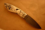 Steckerl<br /><hr />Klingenlänge: 100 mm<br />Gesamtlänge: 220 mm<br />Klingendicke: 2,7 mm<br />Griffmaterial: Elfenbein mit Scrimshaw von Eva Halat<br />Klingenmaterial: Fritz Schneider Damast