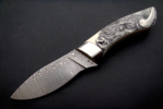 Flacherl<br /><hr />Klingenlänge: 110 mm<br />Gesamtlänge: 225 mm<br />Klingendicke: 3,9 mm<br />Griffmaterial: Elfenbein mit Scrimshaw von Eva Halat<br />Klingenmaterial: Fritz Schneider Damast