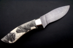 Flacherl<br /><hr />Klingenlänge: 110 mm<br />Gesamtlänge: 225 mm<br />Klingendicke: 3,9 mm<br />Griffmaterial: Elfenbein mit Scrimshaw von Eva Halat<br />Klingenmaterial: Fritz Schneider Damast